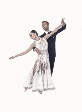 Dans eden balo çifti beyaz sahilde yalnız poz veriyor.