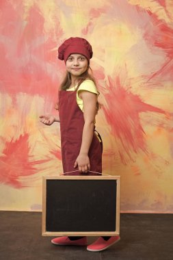 küçük mutlu kız Şef şapkalı, önlük ile yazı tahtası