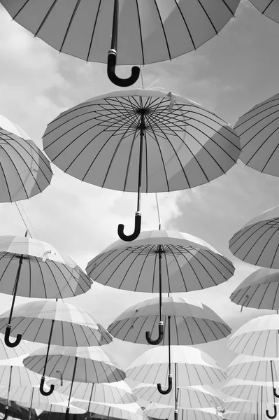 Outdoor art design and decor. Umbrellas float in sky on sunny day. Umbrella sky project installation. Holiday and festival celebration. Shade and protection