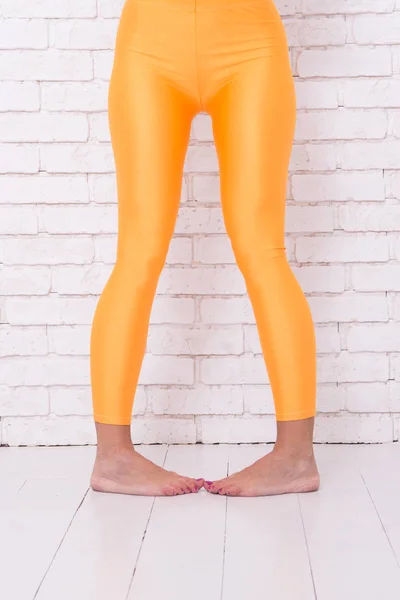 Zabawna dziewczyna w szalonej pozycji tanecznej baletu stóp. kobieta w pomarańczowych legginsach na nogach. Tańcz do rytmu serca. pomarańczowy. ćwiczę w studiu baletowym. moda sportowa. Nadaje się do każdego stylu — Zdjęcie stockowe