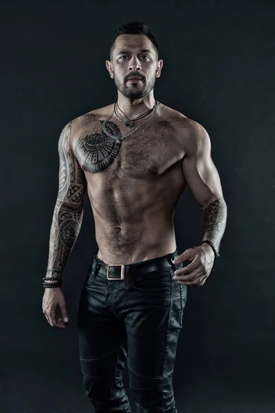 Handsome fit man posing wearing in jeans with tattoo. Tattoo art. Man handsome shirtless muscular with jeans over dark background. Muscular tattooed athlete look attractive. Sport and fashion concept — Stock Photo, Image