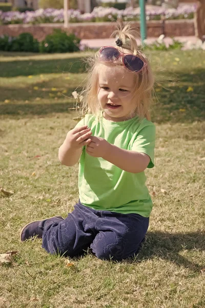 Piccolo bambino con la faccia felice su erba verde — Foto Stock