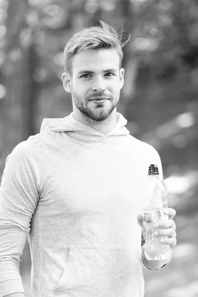 Випий трохи води. Чоловік красивий бігун тримає пляшку води цілком тренування в парку. Чоловік спортсмен спортивного одягу освіжає. Спортивний і здоровий спосіб життя концепція. Спортсмен п'є воду після тренування в парку — стокове фото
