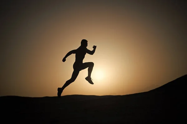 Man loopt silhouet bij zonsondergang, jonge Kaukasische run in Bergen — Stockfoto