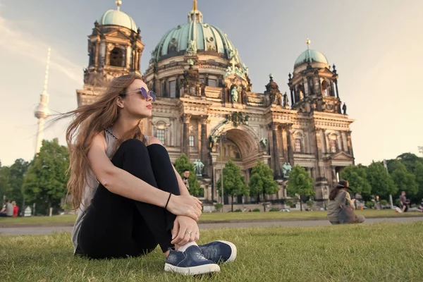 Berlin Katedrali 'nin önünde güneş kremi sürerek oturuyor.