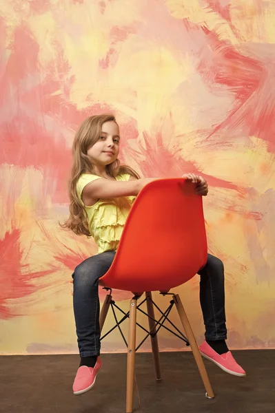 Dziecko lub małe uśmiechnięte dziewczyny, siedząc na krześle pomarańczowy — Zdjęcie stockowe