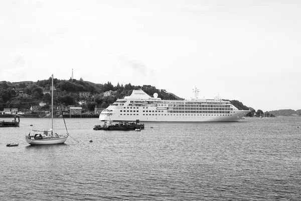 Oban, Regno Unito - 20 febbraio 2010: imbarcazioni in mare lungo la costa montana. Nave da crociera e barche a vela in mare. Viaggiare in acqua. Avventura e scoperta. Vacanze estive e vagabondaggio — Foto Stock