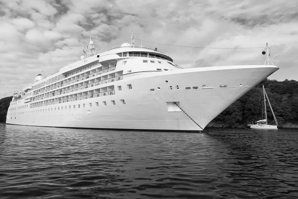 Ocean liner in sea in Fowey, United Kingdom. Cruise ship at seacoast on cloudy sky. Summer vacation on tropical island. Travelling by water with discovery. Wanderlust and adventure — Stock Photo, Image