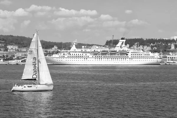 Lizbona, Portugalia - 03 kwietnia 2010: żaglówkę i statek na wybrzeżu błękitnego morza. Łodzi żaglowych i oceanicznego liniowca w morze. Podróżujących dla przyjemności. Podróż przez wodę. Letnie wakacje i wanderlust — Zdjęcie stockowe