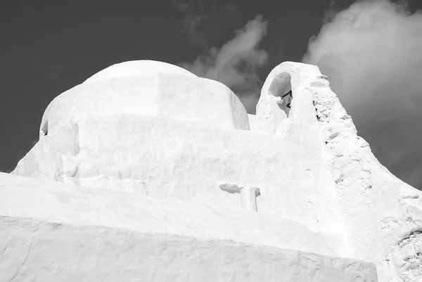 Kuppel und Glockenturm der Panagia Paraportiani Kirche in Mykonos, Griechenland. Kapellenbauarchitektur. weiße Kirche am wolkenverhangenen blauen Himmel. Religion und Kultkonzept. Urlaub auf Mittelmeerinsel — Stockfoto