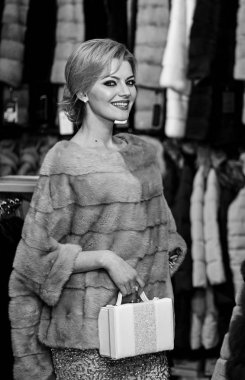 Sarı saçlı bir kadın kürklü palto alır..