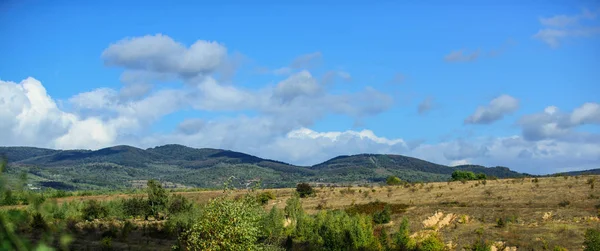 Paisaje natural con montañas cielo azul día soleado. Día de otoño soleado en la naturaleza. Concepto de fondo natural. Campos bosque y montañas naturaleza paisaje — Foto de Stock