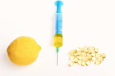 Tıp ve sağlıklı beslenme kavramı. Narenciye meyve ve tıbbi enjeksiyon ile Omega 3 hapı. Şırınga, kapsül ve taze limon beyaz arka plan üzerinde izole. Yağ kapsül tedavisi için şırınga ve balık