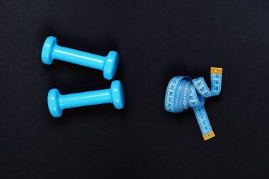 Şekil verme ve fitness ekipmanları. Mezuranın yanındaki halterler