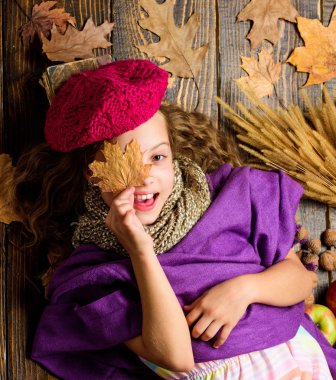 Aksesuar moda ayrıntı ördü. Küçük çocuk kız parlak yumuşak örme şapka bere moda. Sonbahar moda aksesuar kavramı. Moda trend sonbahar sezonu. Kız yatıyordu ahşap arka plan yaprakları yukarıdan düşmüş