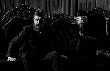 Zarif takım elbiseli milyoner lüks koltukta oturuyor..