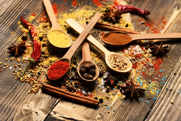 Cuillères en bois avec boules de poivre, paprika, curry et épices sèches — Photo