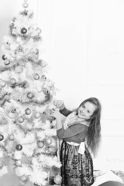 Ребенок украшает елку на Рождество. Зимние праздники и вечеринки — стоковое фото