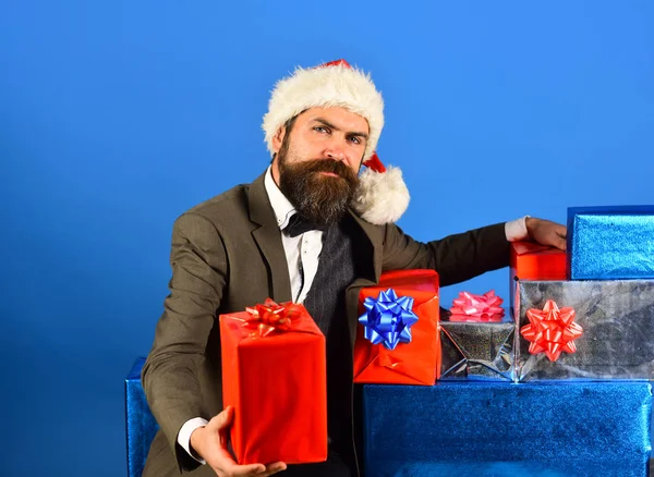Santa i retro kostym presenterar blå och röda gåvor. — Stockfoto