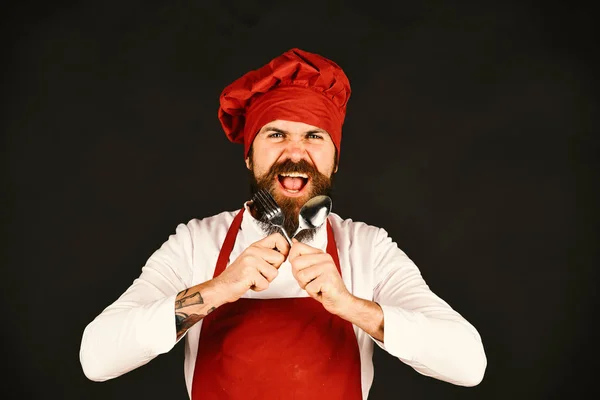 Μάγειρας με άγριο πρόσωπο Βουργουνδία ομοιόμορφη κατέχει μαχαιροπήρουνα — Φωτογραφία Αρχείου