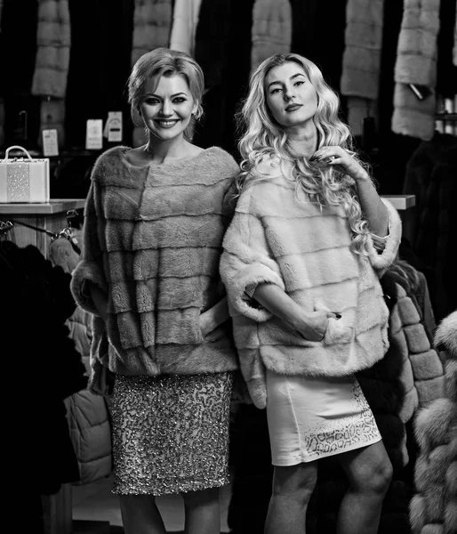 Kobiety kupić futrzany płaszcz. Dziewczyny z wesoły twarze — Zdjęcie stockowe