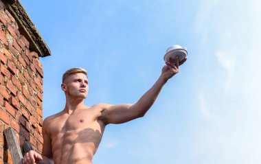 Seksi gövde çekici garson. Adam kas göğüs çıplak gövde fincan kahve gökyüzü arka plan tutun. Adam kas atlet vücut geliştirmeci kahve sunmaktadır. Erkeklik cinsellik güçlü kaslar vurgulamak