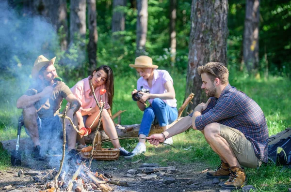 Company having hike picnic nature background. Summer hike. Hikers sharing impression of walk and eating. Picnic with friends in forest near bonfire. Tourists with camera relaxing checking photos — Stock Photo, Image