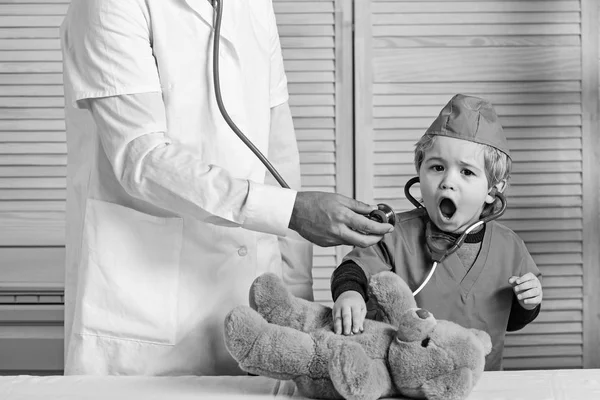 Little assistant examines teddy bear. Health and childhood concept. — Stock Photo, Image