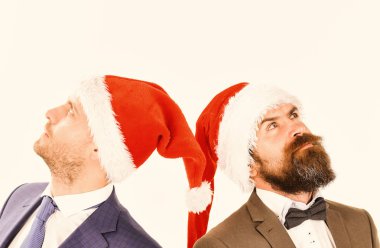 Takım elbiseli adamlar ve beyaz arka planda Noel Baba şapkaları..