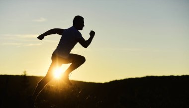 Atlet gün batımında gökyüzü arka planında çalışır, kopyalama alanı.