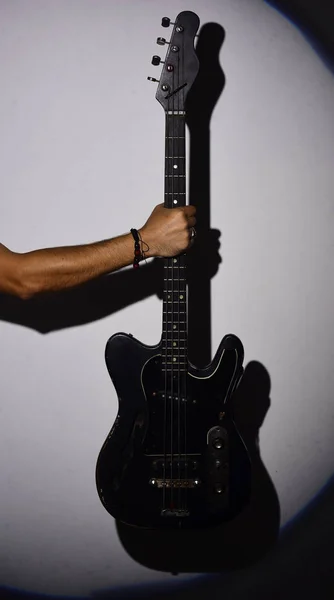 Electric guitar in male hand. Guitar player holds musical instrument