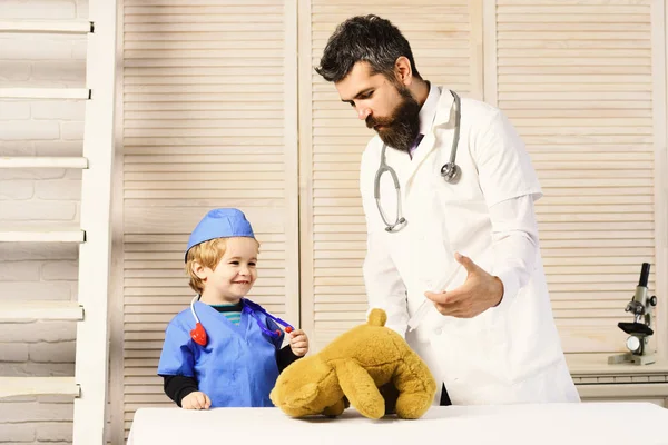 Padre e hijo con caras felices jugando al doctor. —  Fotos de Stock