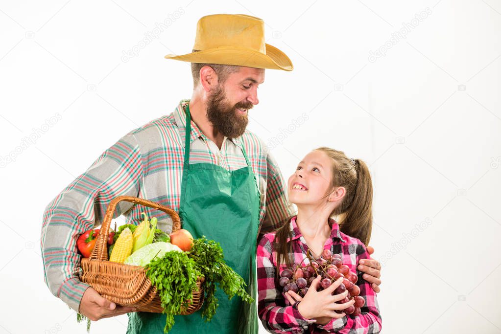 Farmers family homegrown harvest. Gardening and harvesting. Family farm organic vegetables. Man bearded rustic farmer with kid. Father farmer or gardener with daughter hold basket harvest vegetables