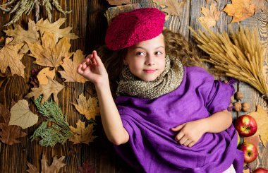 Moda trend sonbahar sezonu. Çocuk yatıyordu ahşap arka plan yaprakları yukarıdan düşmüş. Aksesuar moda ayrıntı ördü. Çocuk kız moda giyim örme şapka bere ve atkı. Sonbahar moda aksesuarları kavramı