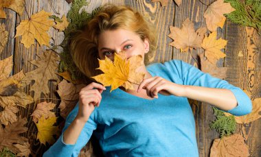 Sonbahar atmosfer öznitelikleri. Kadın güzel bayan rahat sezon tutun sonbahar kuru yaprakları tadını çıkarın. Kız sarışın lay turuncu ahşap zemin üzerine üstten görünüm bırakır. Sonbahar ve sonbahar sezon kavramı