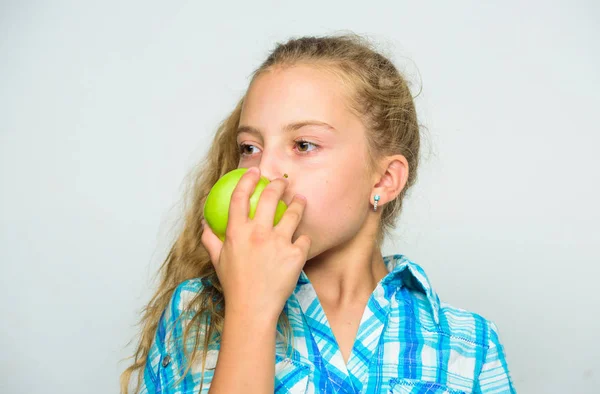 Reasons eat apple every day. Nutritional content of apple. Apple a day keeps doctor away. Good nutrition is essential to good health. Kid girl eat green apple fruit. Vitamin nutrition concept