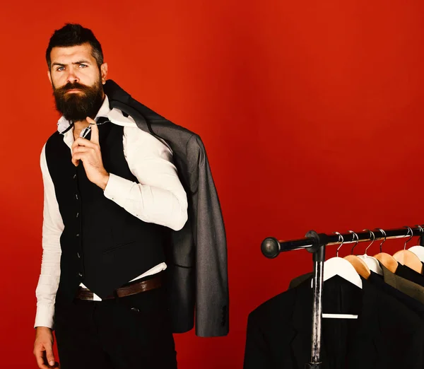 Jonge hipster met baard gekleed in vest staat binnen — Stockfoto