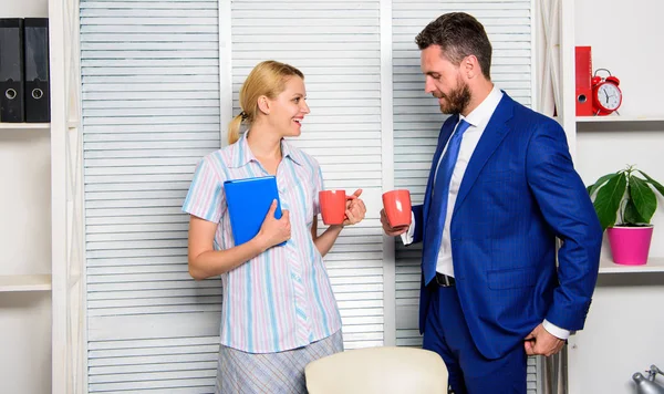 Conversation between colleagues. Boss and worker discuss working plan. Relations at workplace. Colleagues spend time coffee break. Friendship and personal attitude to employee. Office coffee break
