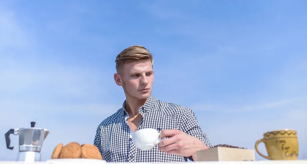 Denní tradice. Snídaně venku víkend tradice. Guy si skvělý začátek dne. Muž drží šálek kávy sky pozadí. Muž svalnatý sportovec pít ranní kávu. Příjemné dopoledne venku — Stock fotografie