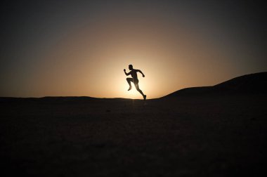 adam siluet günbatımı gökyüzüne çalıştıran