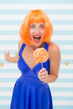 Elinde lolipop olan mutlu poster modeli. Turuncu saçlı moda kızı eğleniyor. Lolipopu olan havalı bir kız. Seksi bir kadın. Oyuncu modunda çılgın bir kız. Hoş görünüş. Çok eğlenceli. Deliriyorum. İyi eğlenceler.