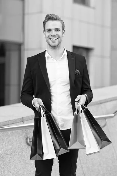 Man stylist professional shopper. Clothes courier. Stylist buy fashionable clothes client. Shopping service concept. Man formal suit shopping mall. Shop assistant helps carries bunch shopping bags