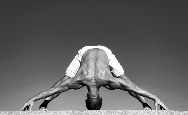 Joga uspokaja organizm. Instruktor jogi z mięśni ciała uprawianie sportu. Muskularny mężczyzna w pozycji jogi. Zdrowia psychicznego i fizycznego. Sport i zdrowie. Ciężka praca jest prawdziwym kluczem do sukcesu, czarno-białe — Zdjęcie stockowe