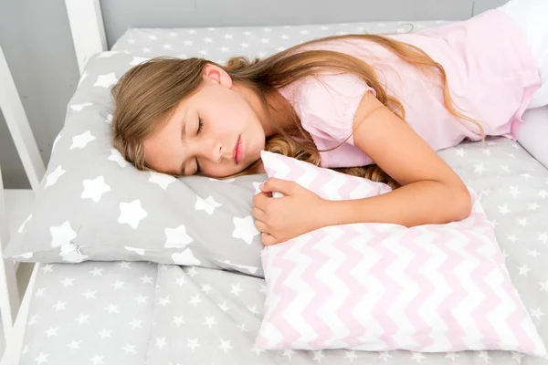 Choose proper pillow to relax well. Healthy sleep tips. Girl sleeps on little pillow bedclothes background. Girl child long hair fall asleep pillow close up. Quality of sleep depends on many factors — Stock Photo, Image