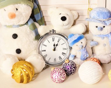 Kardan adam, oyuncak ayı ve Noel ağacı topları çalar saatin yanında.