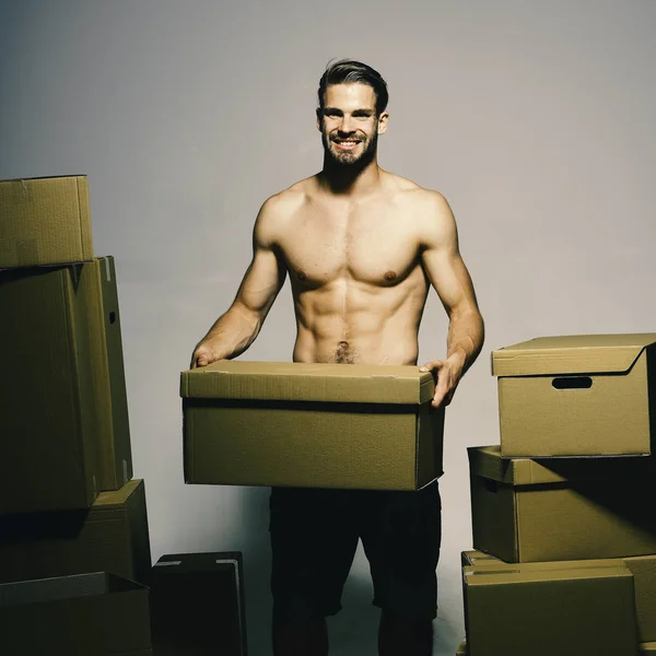 Cargador con torso desnudo deportivo sostiene la caja en frente. — Foto de Stock