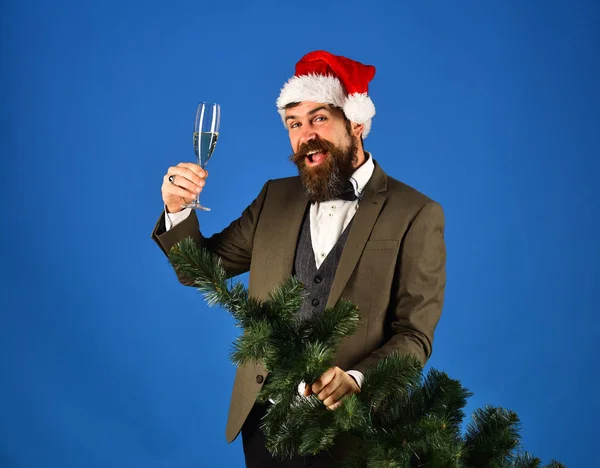 Man in smart suit and Santa hat on blue background.