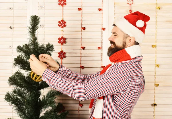 Man with beard in checkered shirt holds golden Christmas ball. — Stock Photo, Image