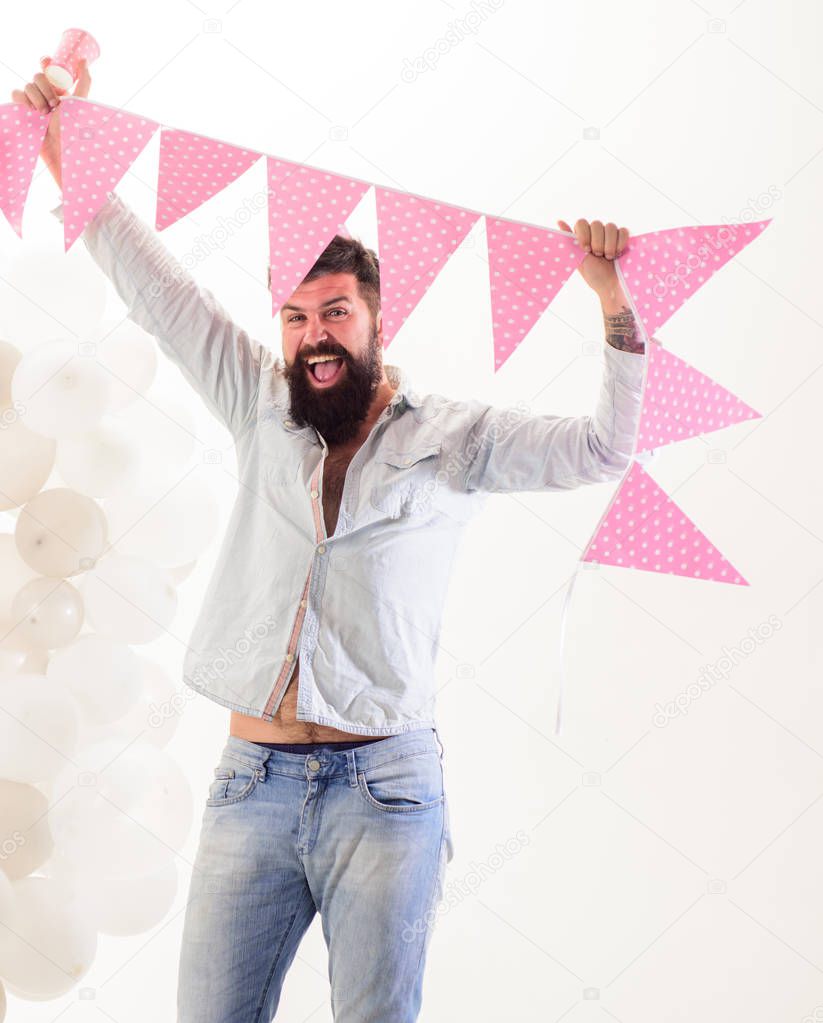 Man bearded hipster with flag garland celebrate birthday. Birthday party supplies. Guy cheerful mood organize birthday party. Decoration and festive attributes. Birthday organization tips concept