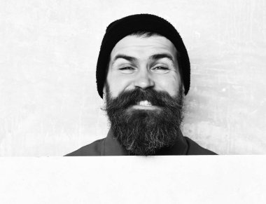 Stüdyo duvarında poz veren sakallı adam.